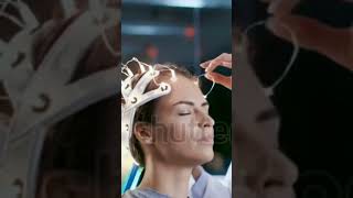 Woman Wearing Brainwave Scanning Headset Sits in a Chair while Scientist Adjusts the Device