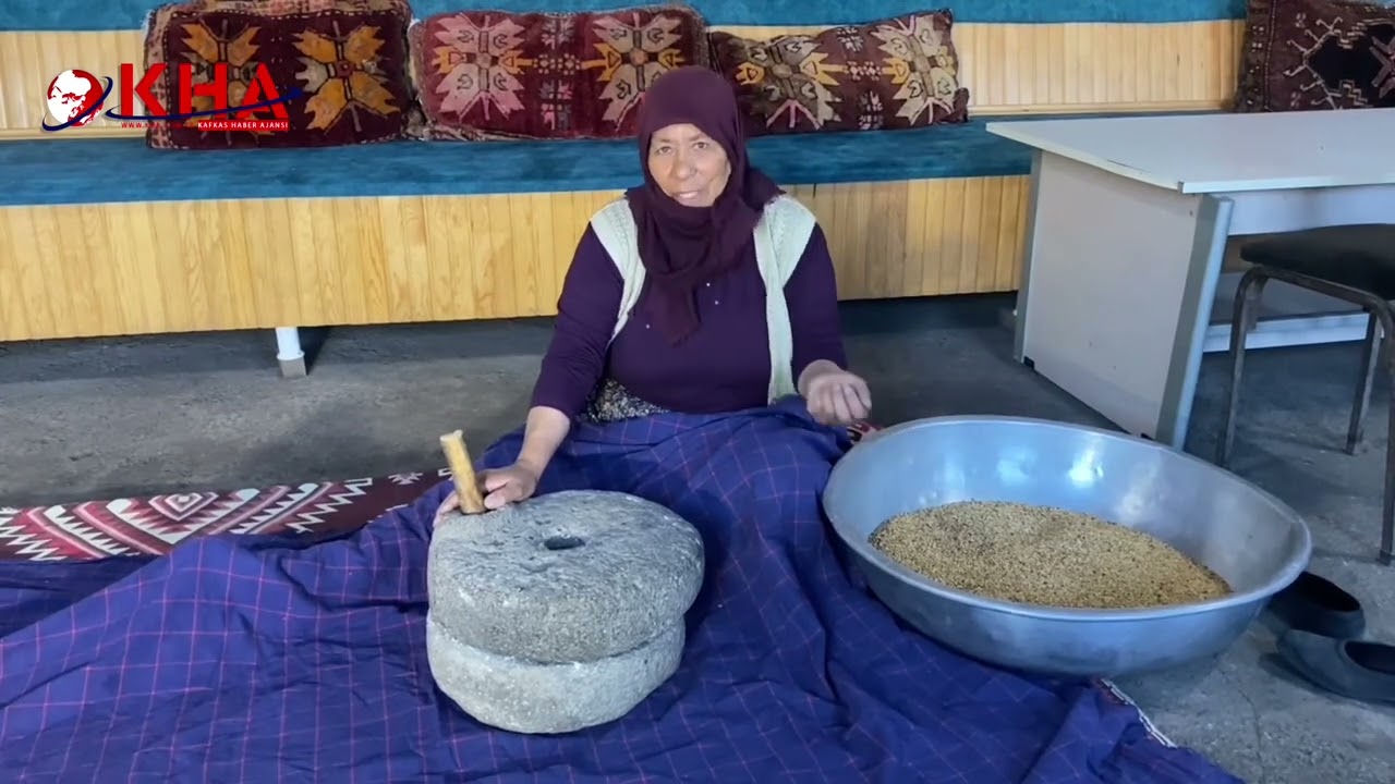 Köyde kavut tatlısı için el değirmeni kullanıyor