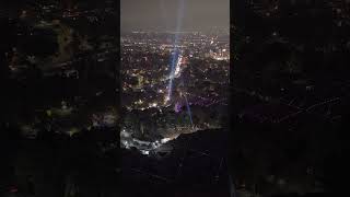 Nighttime aerial of Hollywood Bowl showcasing spectacular lights over illuminated Los Angeles