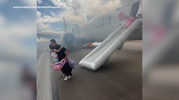 American Airlines passengers exit plane via emergency slide after aborted takeoff in Denver