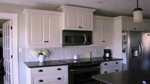 Kitchen backsplash with white cabinets and dark countertops