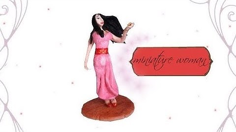 Polymer clay miniature woman holiding a music box