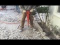 Jack hammering concrete with high powered air jack hammer