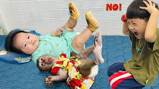 cute lying position of Diana monkey and baby lying still so Roma can wear socks when it's cold