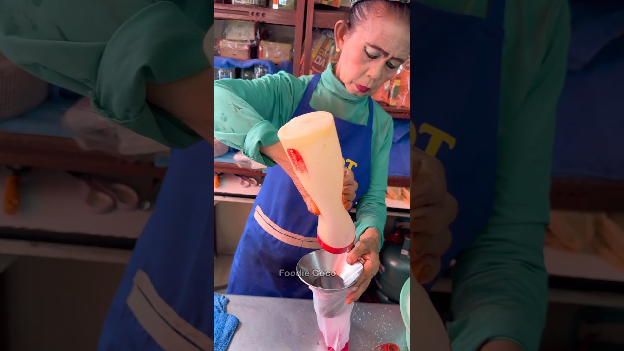 Тайская тетушка готовит сладкое розовое молоко - тайская уличная еда