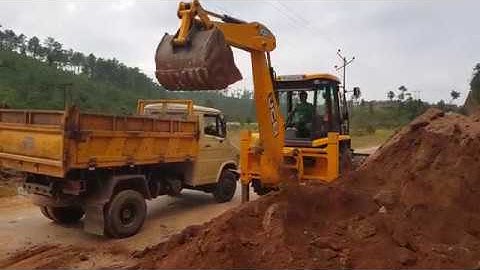 Jcb backhoe loader loading soil into a dump track
