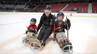 Brady Tkachuk sledge hockey with a young fan