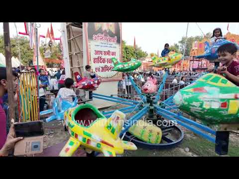 Children ride colourful toy airplanes at the Durga Puja fair in CR Park, Delhi