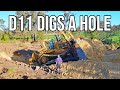 Big d11 bulldozer digs a big hole