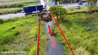 Bulldozer Komatsu D20P started construction roan on the water with dump trucks unloading