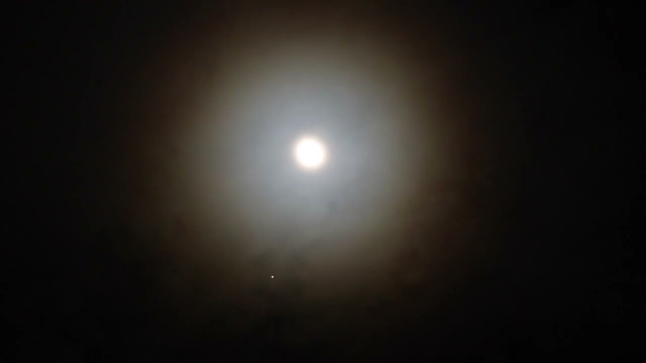Clouds Moving Over The Moon Through A Circle Of Light - Timelapse