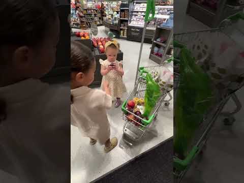 Daphne trying to get a can of silly string #motherhood #shopping