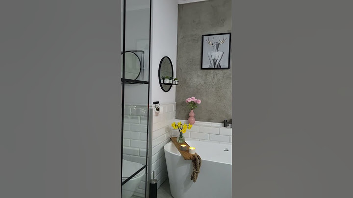 Salle de bain blanche et grise avec des accessoires noirs de style loft