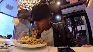 Black man eats a plate of Lo mein with chopsticks