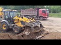 Погрузка грунта экскаватором-погрузчиком JCB в самосвалы