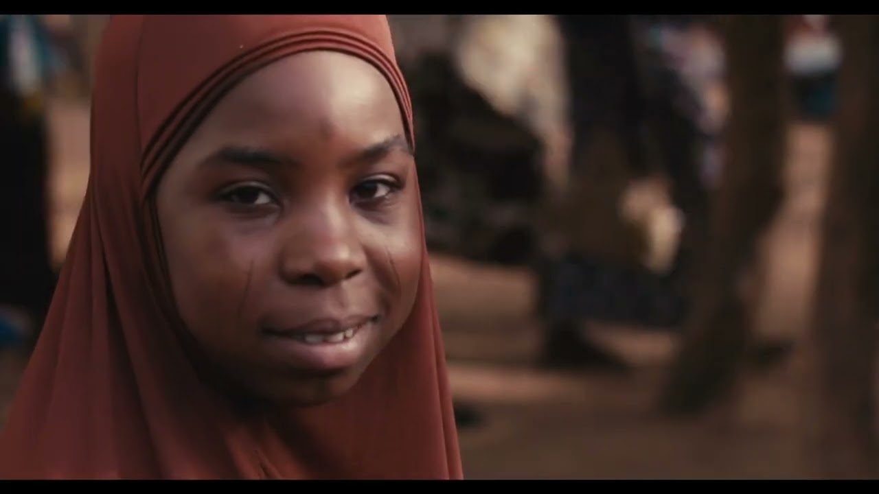 Par ici, l’envoyée de Dieu est choisie par hasard et soumise à des rites funéraires.
Fatima, douze ans, déposée dans un marché, portant une ceinture d’explosif activée dix
minutes pour tuer les ennemis d’Allah. Pendant neuf minutes, c’est un voyage intérieur
durant lequel, elle passe du présent au passé. Fatima se rappelle que sa mère vend dans ce marché.

Right here, the suicide bomber is chosenby chance, and is subjected to funeral rites in order to accomplish the work of God. Fatima, twelve years old, dropped off in a village market, wearing an explosive belt marked ten minutes to kill the enemies of God. For nine minutes, it is an inner journey during which she passes from the present to the past. Fatima discovers that this is the market where her mother sells.