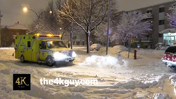 4K UHD - Snow plow pulling stuck ambulance out of snow bank