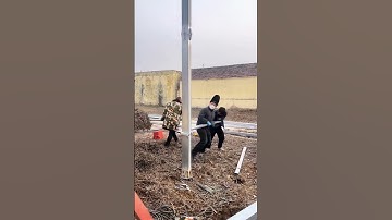 Four Workers Cooperating to Install Steel Column, Busy Construction Scene!