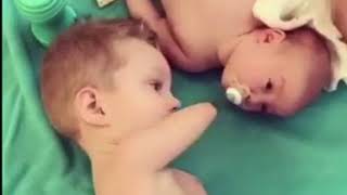 Безрукий маленький мальчик заботится о новорожденном братике