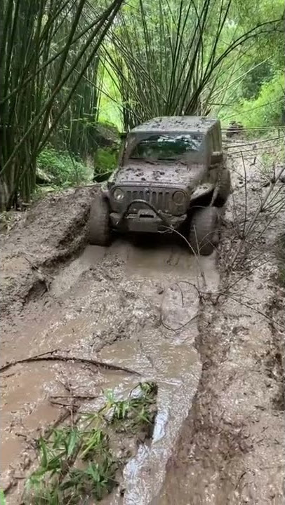 Off road in big rain mud trail with Jeep Wrangler JL