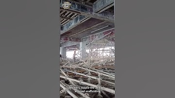 Workers topple the already erected scaffolding