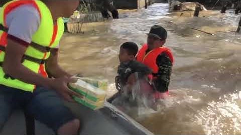 Xót xa cảnh bé trai nỗ lực bơi trong dòng nước lũ lấy hàng cứu trợ