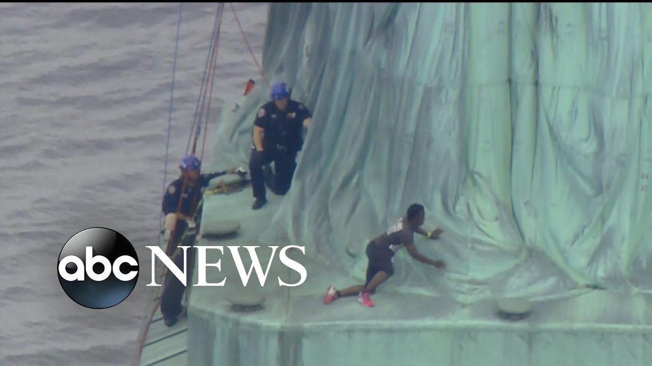 Protester who climbed Statue of Liberty's base is charged for the 'dangerous ...