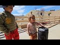Documentary about nomadic family life: making a building and cooking meat daisy and children playing