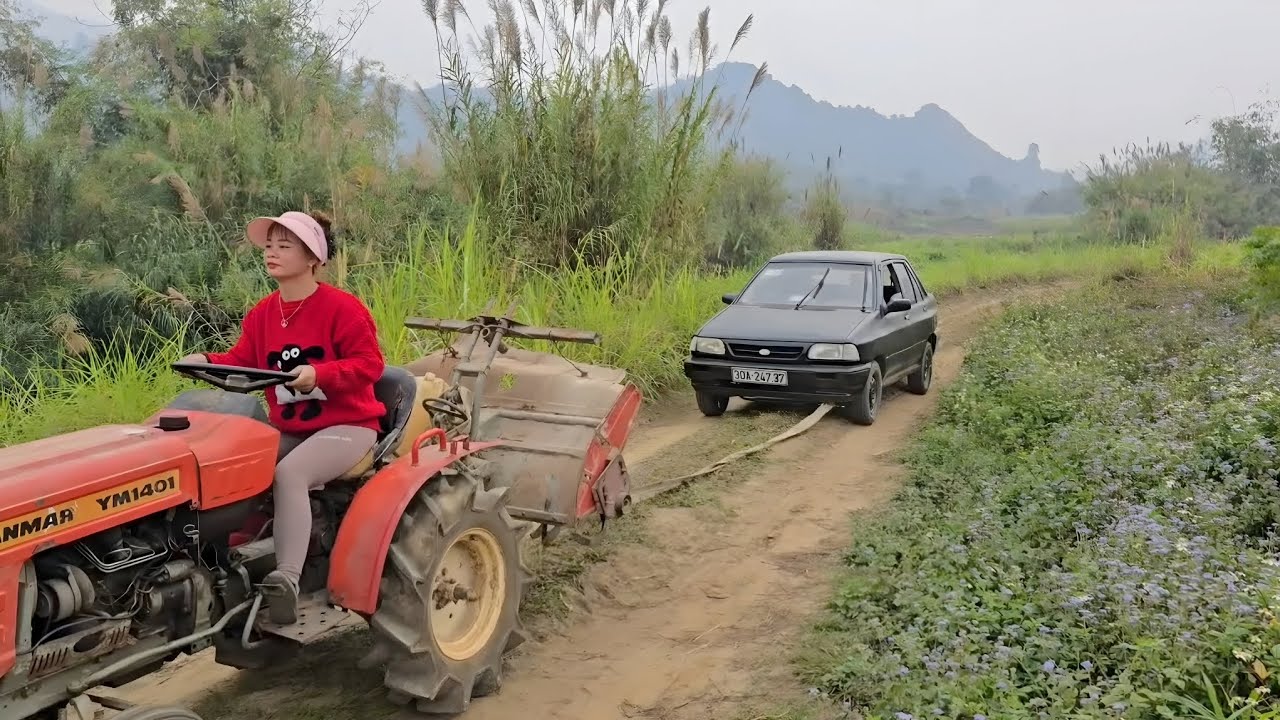Girl repairs and restores a heavily damaged car in the middle of the road.