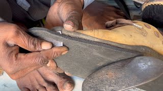 Skillful hands of a cobbler re-crafting shoes - Shoe sole repair by a road side cobbler