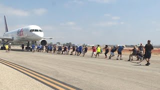 How Many People Does it Take to Pull a Plane Across a Runway?