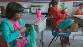 Young students learn to knit warm scarves for the homeless