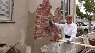 Stucco plastering a brick chimney.