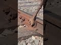 The process of tightening a nut on the iron part of the train track is carried out by an expert