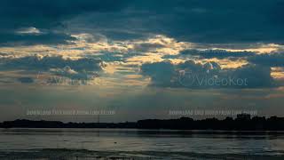 Dramatic blue sky with rays of the breaking sun over the river timelapse