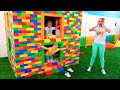Vlad und Niki spielen mit farbigen Spielzeugblöcken und bauen ein dreistufiges Haus