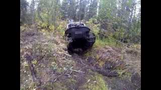 Argo with tracks climbs steep bank from creek while towing trailer!