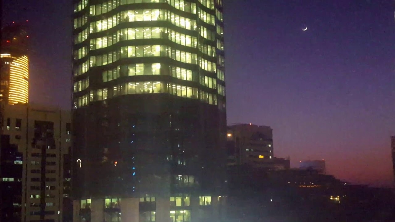 Crescent Moon In The Sky At Sunset and Early Night With Skyscrapers View