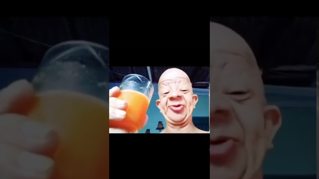 Bald guy drinks orange juice