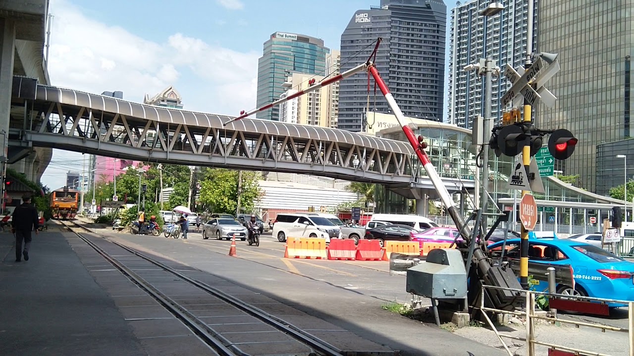 タイ国鉄 ローカル線  アソーク乗降場にて。なかなか閉められない踏切と、車を待つ列車。