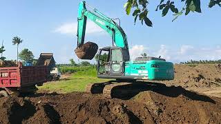 Beko Excavator lifts soil onto a truck.