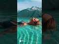 A bikini beauty diving into the pool against a breathtaking backdrop!