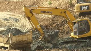 Excavator working cutting mud stone canals loading construction dump truck Delivery pouring