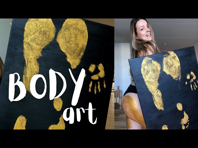 Artist painting beautiful young model in gold color paint, body