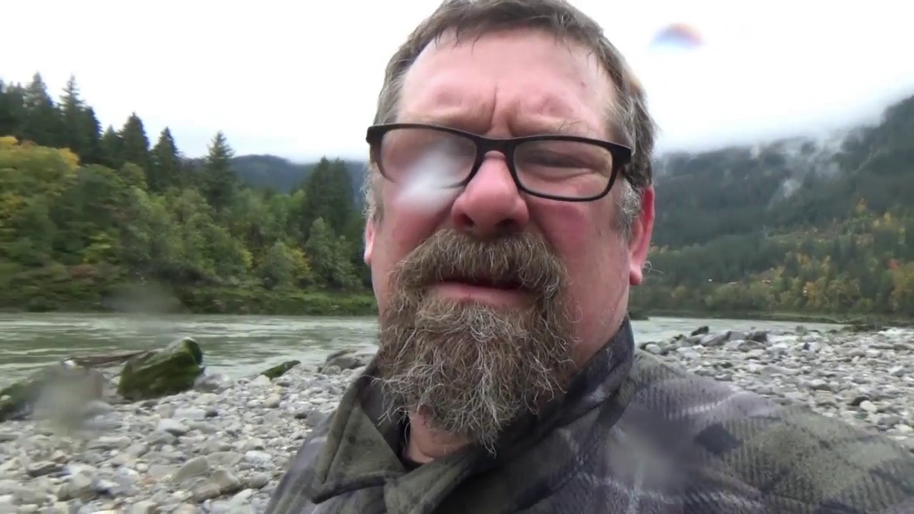 Gold prospecting and panning on the Fraser River in the cold rain