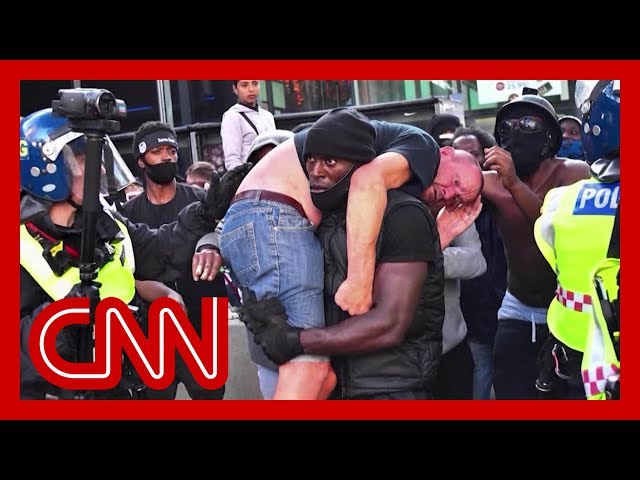 Black Lives Matter demonstrator carries injured white protester to safety in powerful image