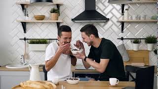 young gay couple are sitting at the table and having breakfast
