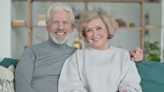 14- Old Couple Sitting On Sofa And Smiling At Camera