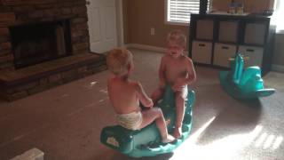 Twin brother having giggles on teeter totter