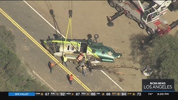 Crane hoists up wreckage of LASD helicopter that crashed Saturday in Angeles National Forest